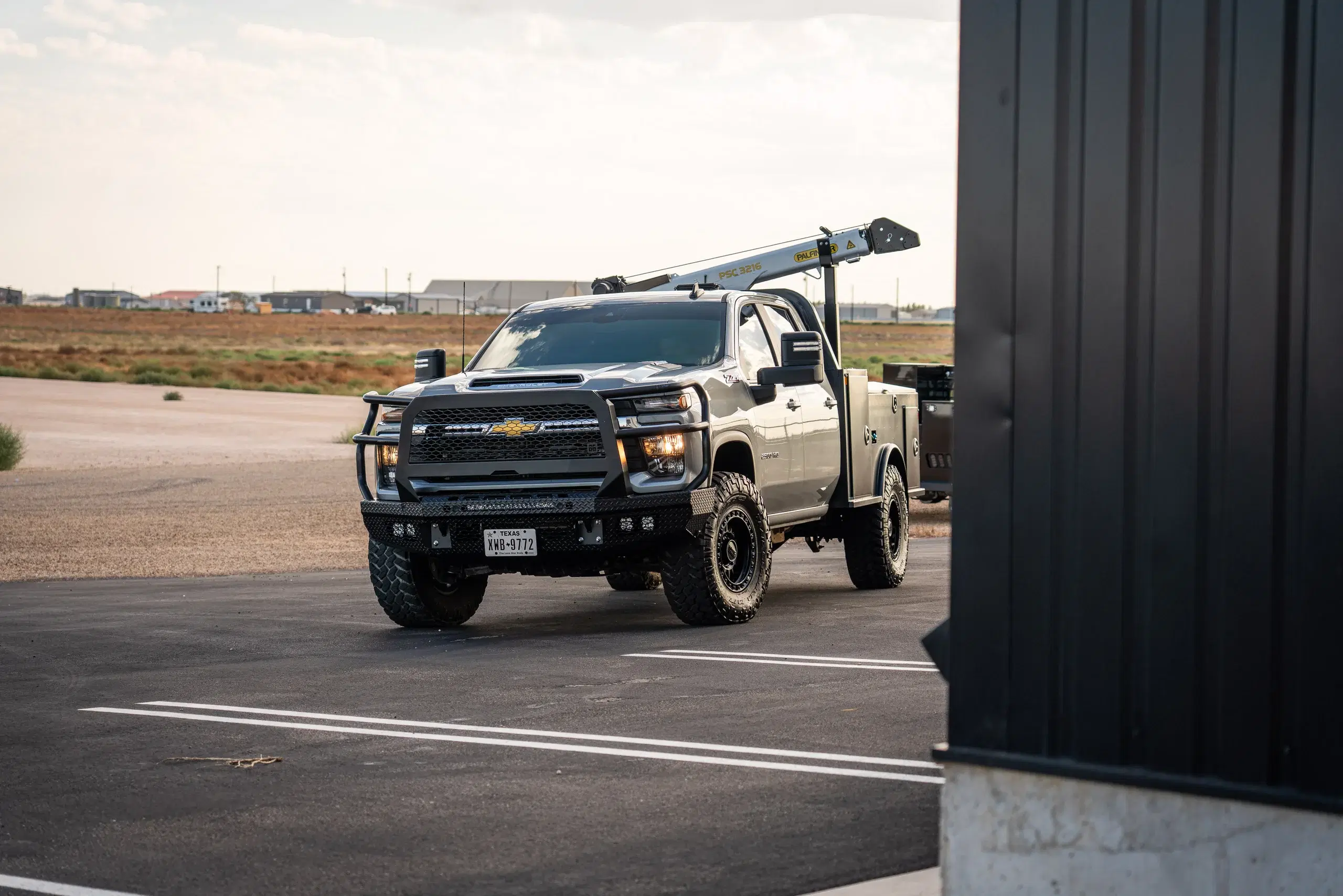 Chevrolet work truck equipped with a Legend X service body and crane outside the Legend X shop