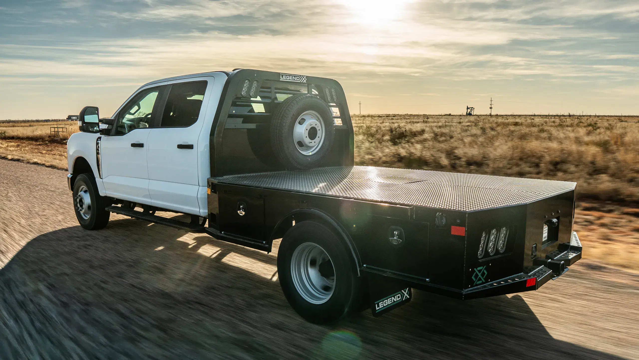 Viking flatbed on a white Ford dually in a rolling golden-hour view